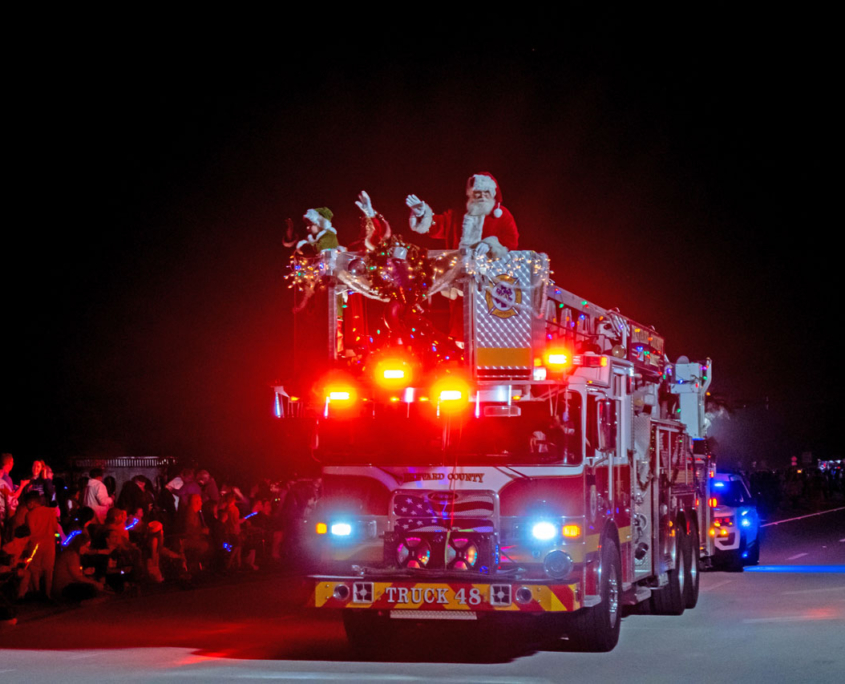 Santa waves from a fire truck.
